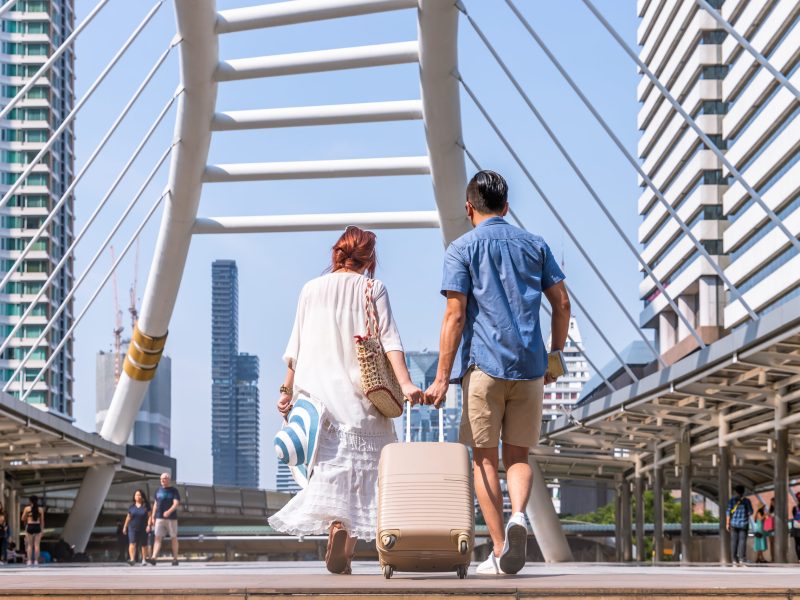 Young asian couple walking with luggage travel summer vacation or honeymoon trip